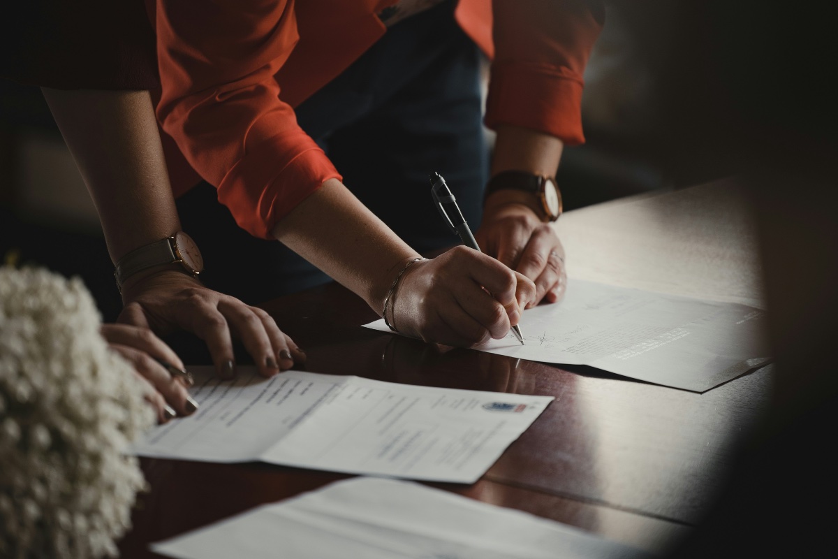 two people signing documents so their pet can fly.