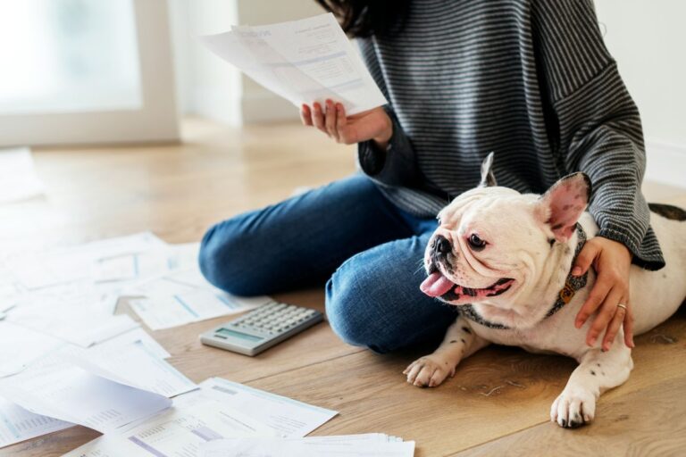 Woman sitting next to her dog going through papers.